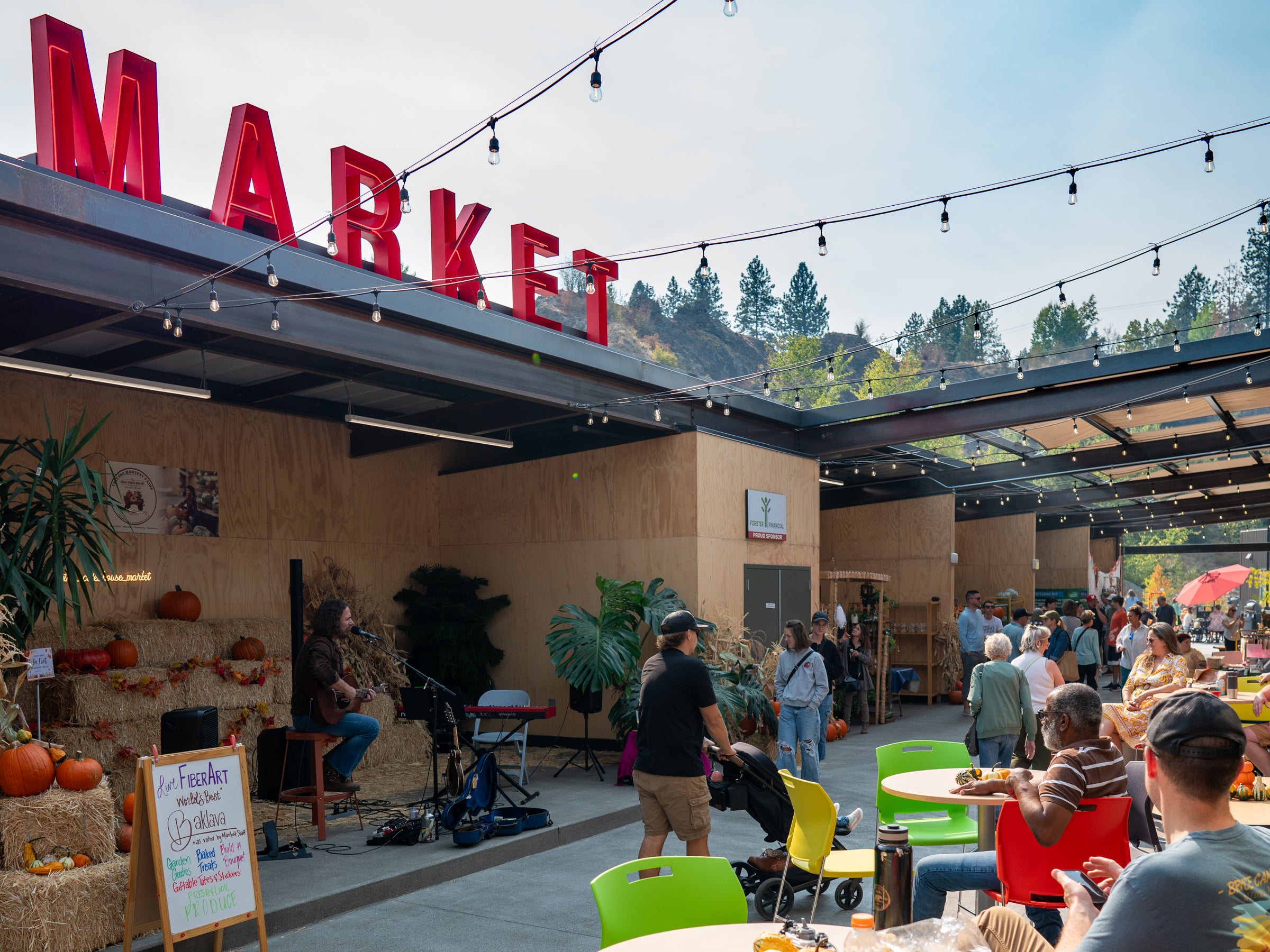 Outdoor market scene with 'MARKET' sign and people milling about.